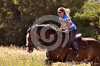 Girl riding horse in meadow Stock Photo