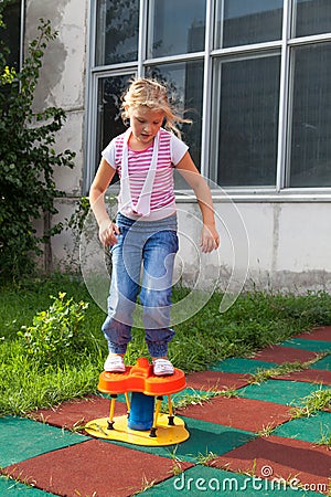 Girl riding rides on a child playground Stock Photo