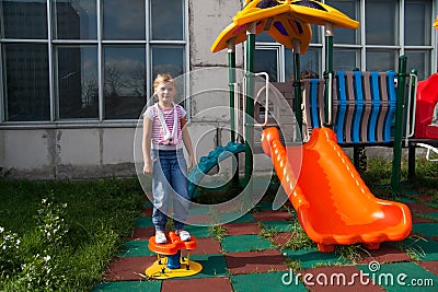 Girl riding rides on a child playground Stock Photo