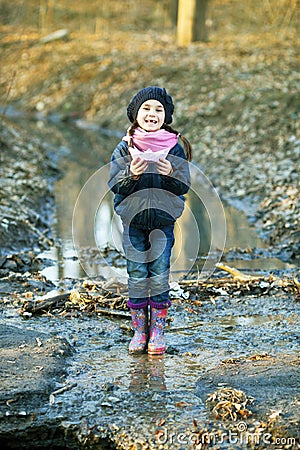 Girl on the river bank plays Paper Boat Stock Photo