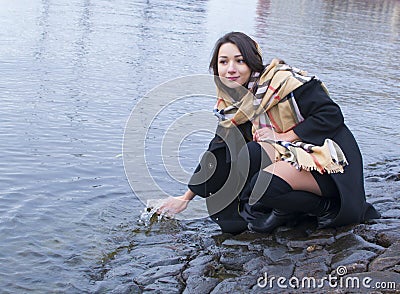 The girl at the river on a stone bridge. Stock Photo