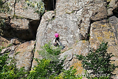 Girl rock climber climbs on a rock Editorial Stock Photo