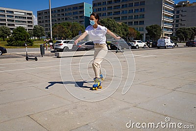 Girl rollerblading wearing covid facemask. Coronavirus protection virus. Outdoor fitness exercise Editorial Stock Photo