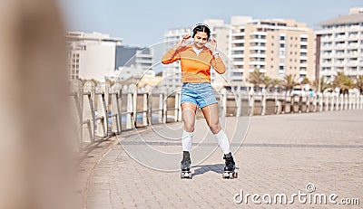 Girl, rollerskates and smile with headphones, boardwalk and fun by ocean, sea and outdoors for hobby. Active person Stock Photo