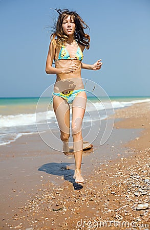 Girl running along seashore Stock Photo