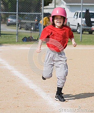 Girl running in baseball Stock Photo