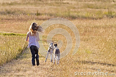 Girl running with dogs Stock Photo