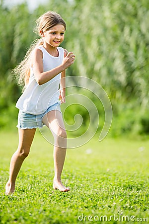 Girl running and jumping on grass Stock Photo