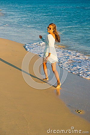 Girl runs along the surf line Stock Photo