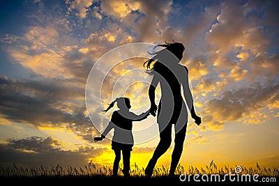 Girl runs with her daughter at sunset Stock Photo