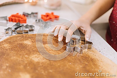Girl`s hand pressing metal cookies cutter on rollout dough Stock Photo