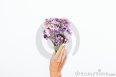 Girl`s hand with white manicure holding small bouquet Stock Photo