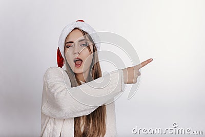 He girl in santa claus hat pointing something by her finger Stock Photo