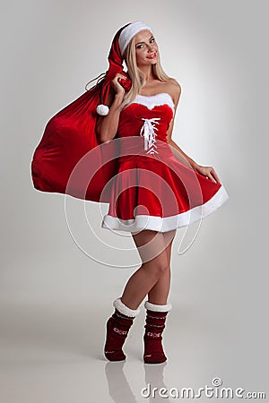 Girl in santa dress with gift bag Stock Photo