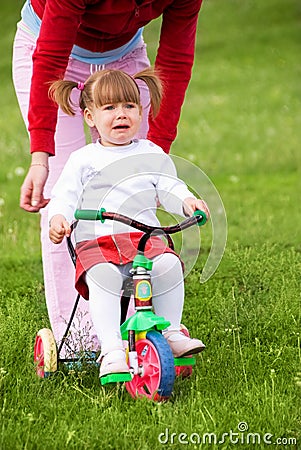 Girl scared of riding a bicycle Stock Photo