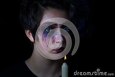 Girl in scary makeup with lite candle on black background Stock Photo