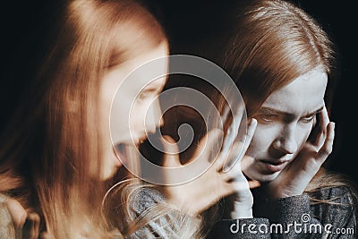 Girl with schizophrenia covering ears Stock Photo