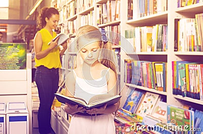 Girl in school age looking in open chosen book Stock Photo