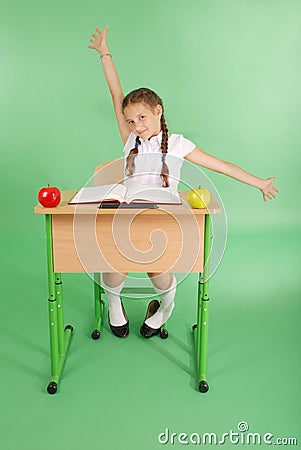 Girl in a school uniform sitting at a desk and stretches Stock Photo