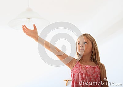 Girl screwing bulb Stock Photo