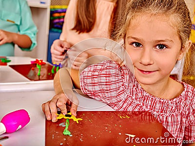 Girl sculpt of plasticine on desk in Stock Photo