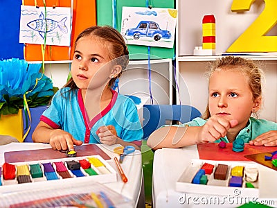 Girl sculpt of plasticine on desk in Stock Photo