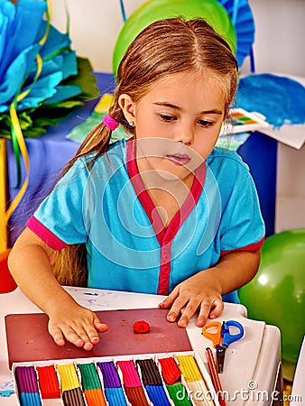 Girl sculpt of plasticine on desk in Stock Photo