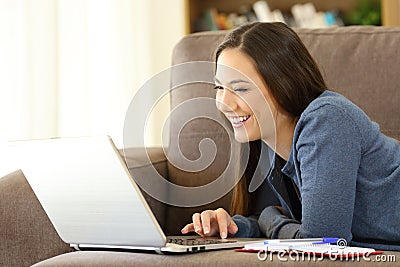 Girl searching online content in a laptop at home Stock Photo
