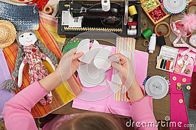 Girl sews doll clothes, top view, sewing accessories top view, seamstress workplace, many object for needlework, handmade and hand Stock Photo