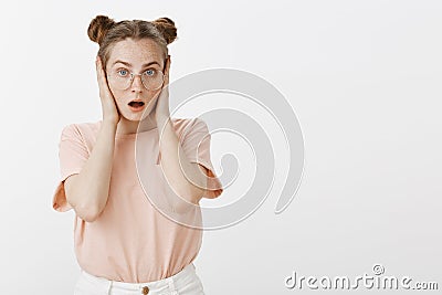 Girl shocked hearing cursing words, closing ears not to hear insults, dropping jaw from surprise and amazement, gazing Stock Photo