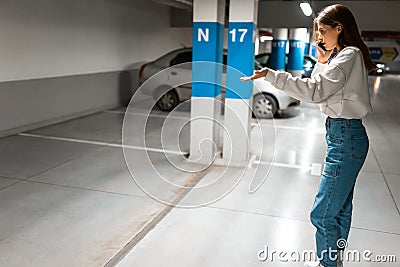 Girl after shopping discovered the loss of her automobile. Angry woman talking about missing car on phone. Vehicle theft concept. Stock Photo