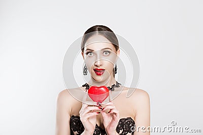 The girl showing the affection, holds the heart in her hands, the expression of the girl is a little surprise, amazing isolated Stock Photo