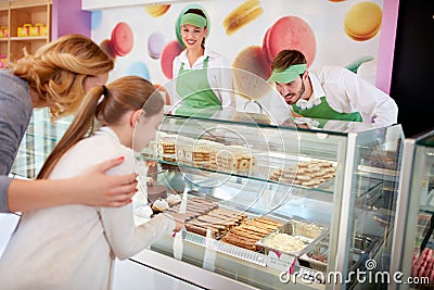 Girl shows cookies in show glass in bakery Stock Photo