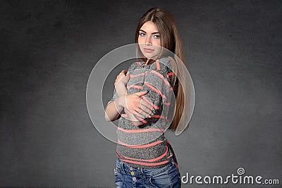 Girl shows modesty or shyness against a dark background Stock Photo