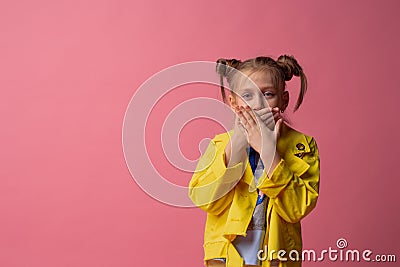 Girl shut her mouth with her hands in yellow clothes on pink background. concept of silence Stock Photo