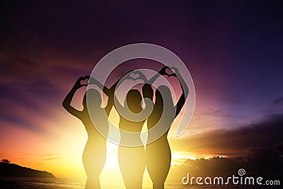 girl silhouettes hands making heart shape with sunset background Stock Photo