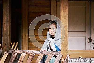 Little girl silver cloak hood looking sky old abandoned house building fairy tale story blue eyes riding Stock Photo