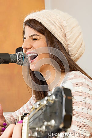 Girl singing loud and playing guitar Stock Photo