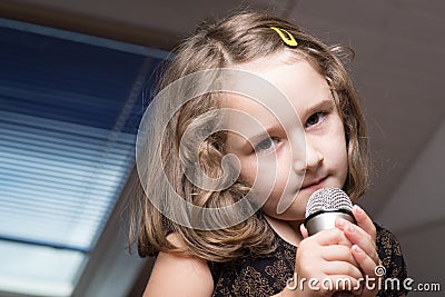 Girl singing on a microphone Stock Photo