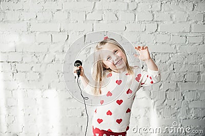 The girl sings in a microphone Stock Photo