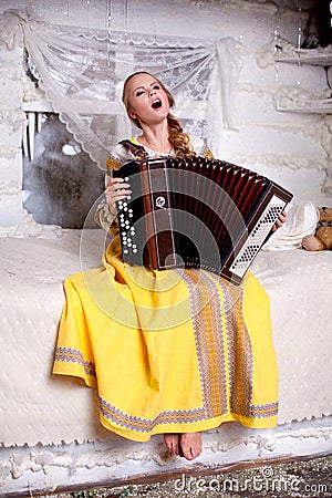The girl sings and plays the accordion Stock Photo