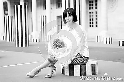 Girl sit on striped column in paris, france Stock Photo