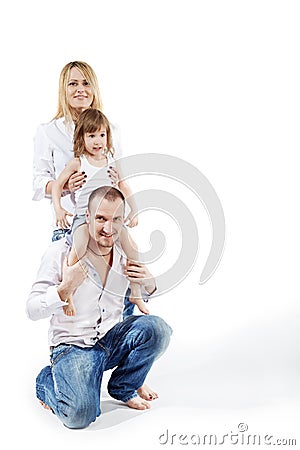 Girl sits on father shoulders, mother supports her Stock Photo