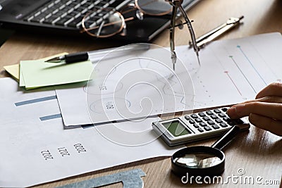 The girl sits at her desk and draws up graphs and histograms about income, business and finance, planning , economics Stock Photo