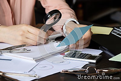 The girl sits at her desk and draws up graphs and histograms about income, business and finance, planning , economics Stock Photo