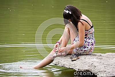 A girl sits at the river Stock Photo