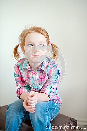 Girl sits on suitcase Stock Photo