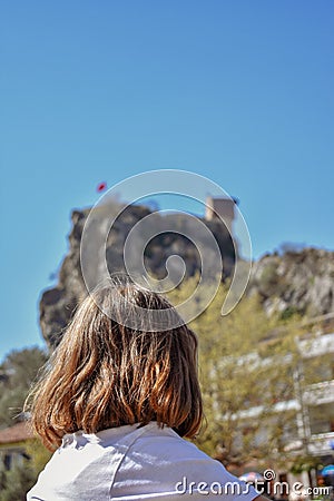 Girl is sitting alone and watching the castle Stock Photo