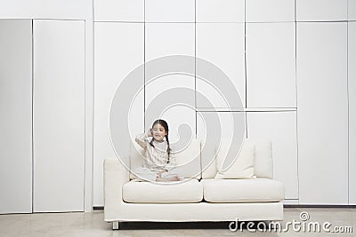 Girl Sitting Cross Legged On Sofa Stock Photo