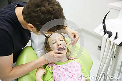Girl sitting on dental chair on her regular dental checkup Stock Photo